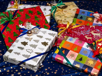 A stack of gifts wrapped in understated paper on a table